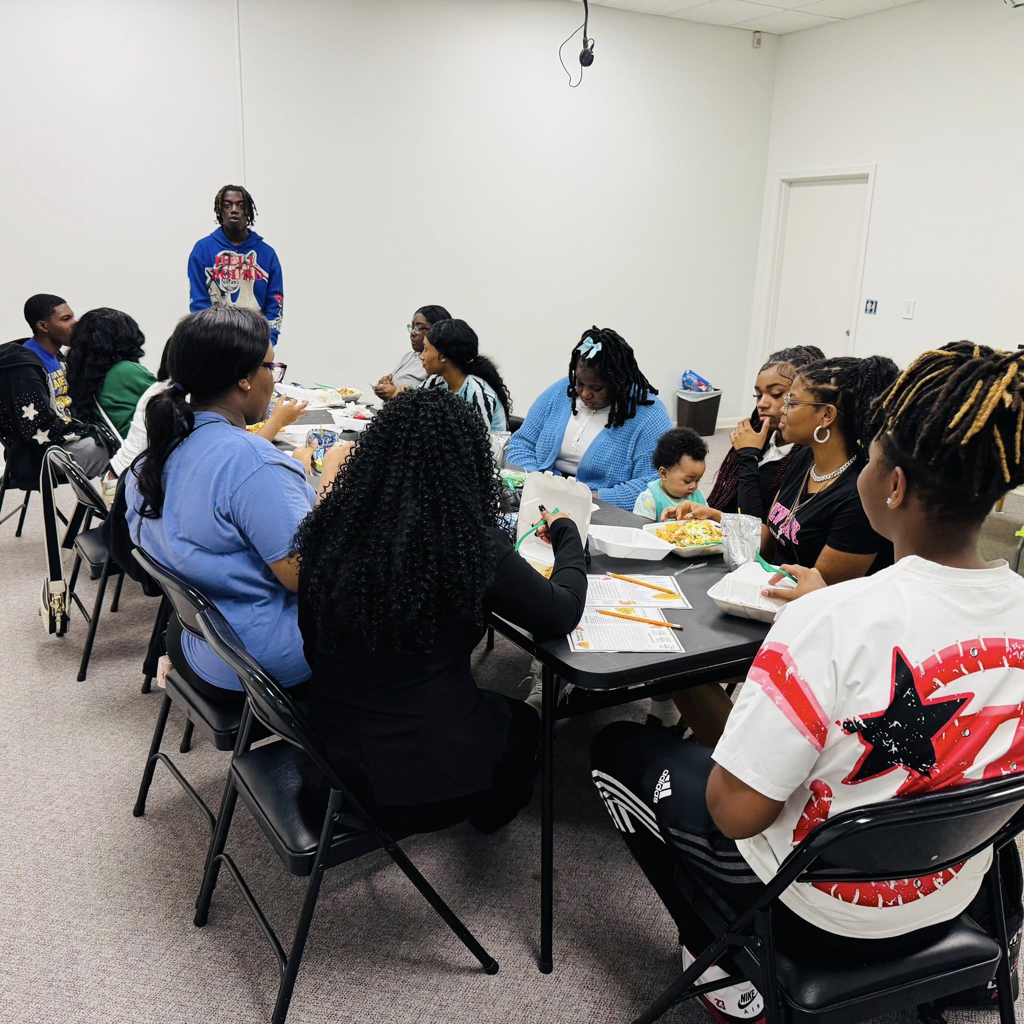 A group of teens sitting at a table.